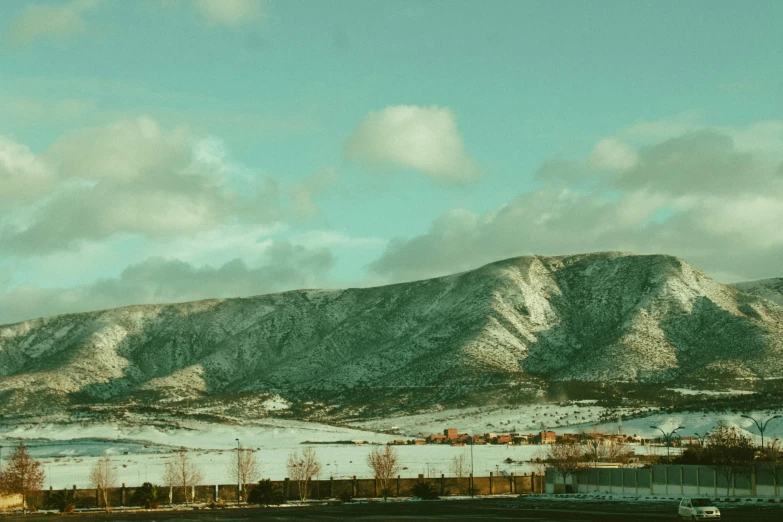 a large mountain covered in snow next to a field, inspired by Elsa Bleda, trending on unsplash, visual art, neighborhood, background image, new mexico, cinematic shot ar 9:16 -n 6 -g