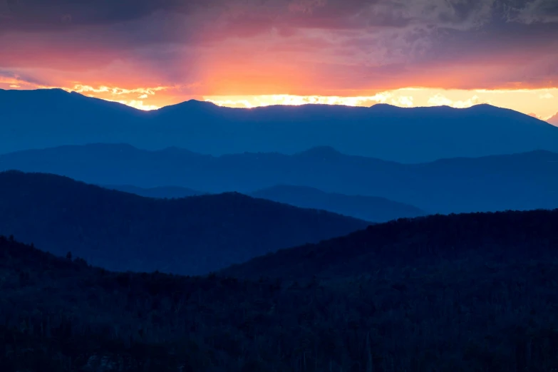 the sun is setting over the mountains in the distance, inspired by LeConte Stewart, unsplash contest winner, blue and orange, light show, he is from virginia, 3 layers of sky above each other