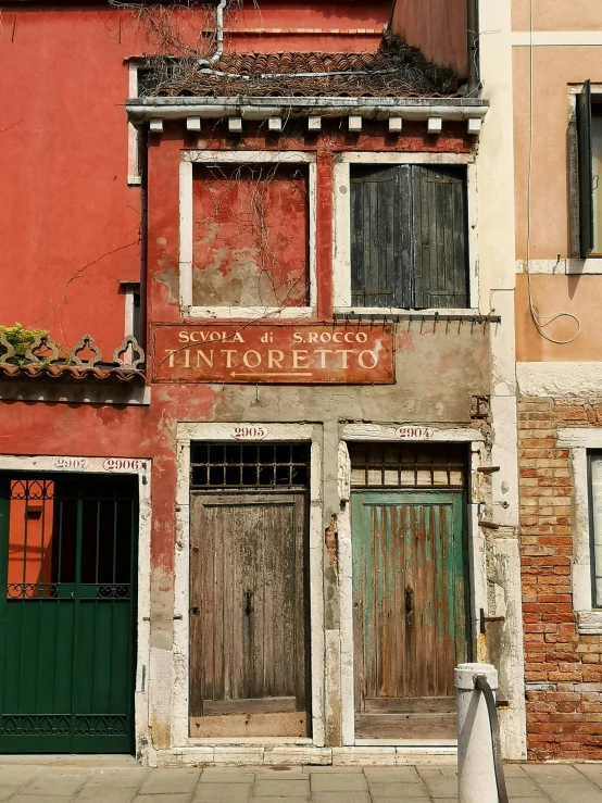 a couple of buildings that are next to each other, an album cover, inspired by Quirizio di Giovanni da Murano, pexels contest winner, dull red flaking paint, colorful signs, viridian and venetian red, 2006 photograph