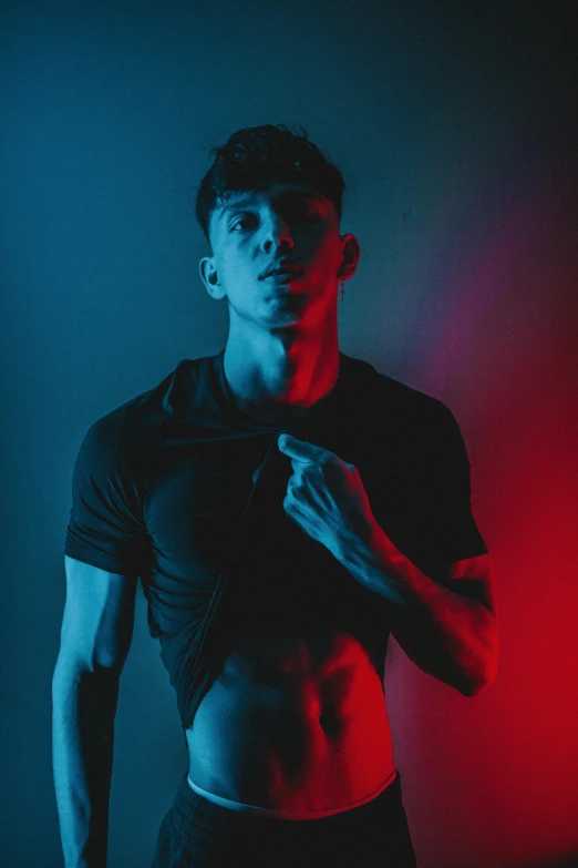 a man standing in front of a red and blue light, pexels contest winner, fitness model, non binary model, asher duran, 18 years old