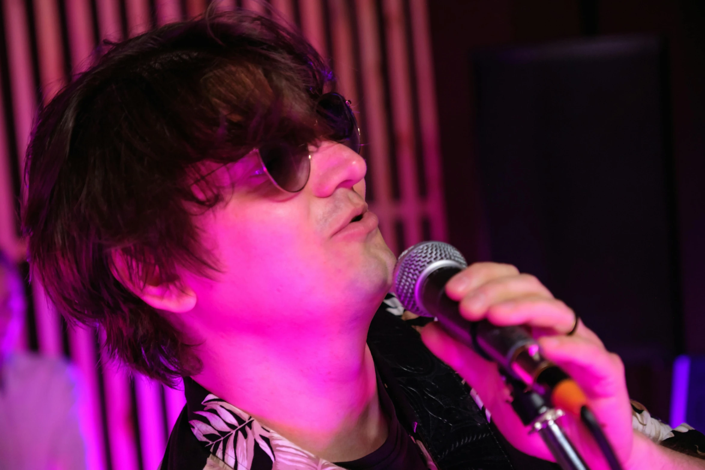 a close up of a person holding a microphone, an album cover, pexels, art brut, with sunglass, blur studio, jonny greenwood (lead guitar), performing