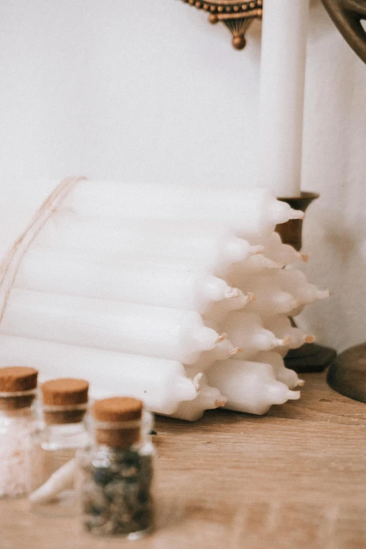 a group of candles sitting on top of a wooden table, white human spine, made of lab tissue, promo image, sustainable materials