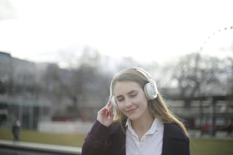 a woman with headphones talking on a cell phone, an album cover, pixabay, realism, calm weather, light toned, student, high - res