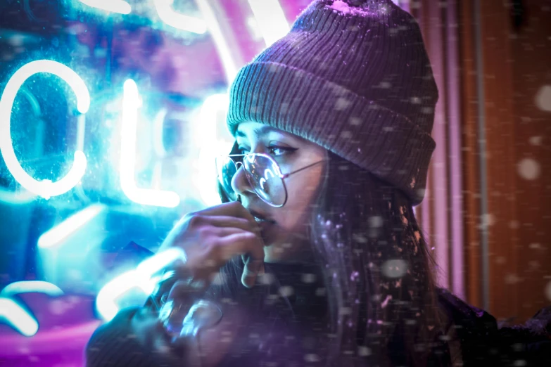 a woman talking on a cell phone in front of a neon sign, a portrait, inspired by Liam Wong, trending on pexels, lens flare snow storm, drinking and smoking, wearing a beanie, avatar image