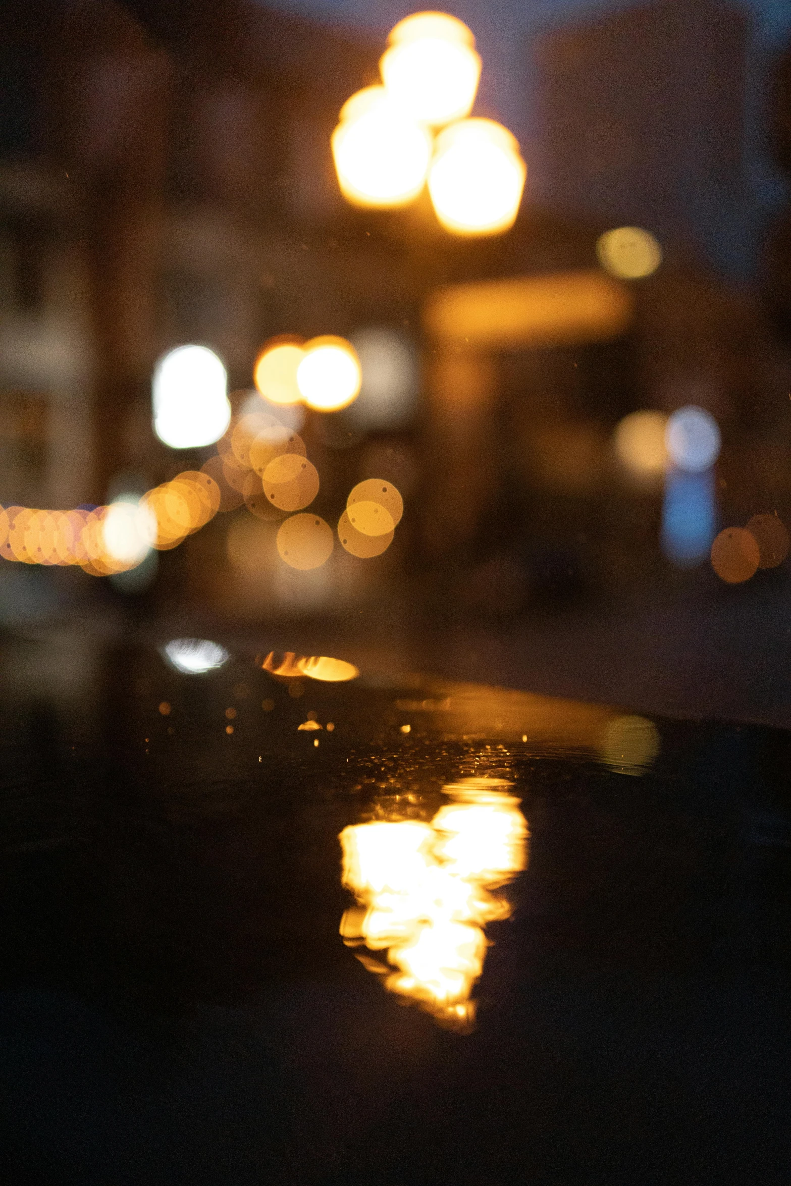 a blurry image of a city street at night, by Daniel Seghers, trending on unsplash, wet reflections in square eyes, close - up bokeh, candlelit, reflections in copper