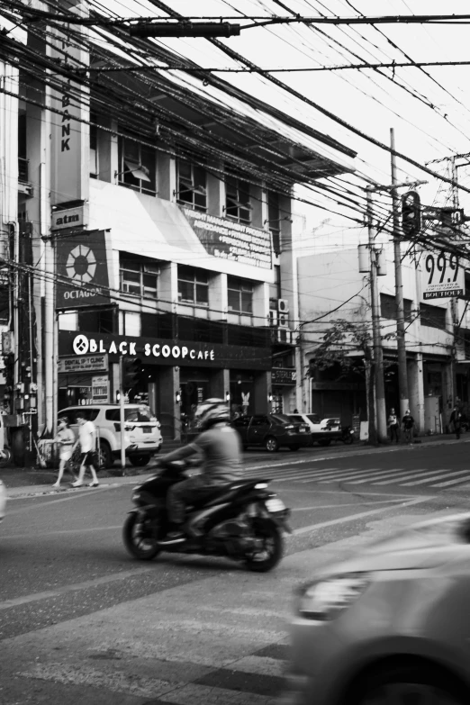 a black and white photo of a city street, a black and white photo, philippines, riding a motorbike, black! and white colors, shops