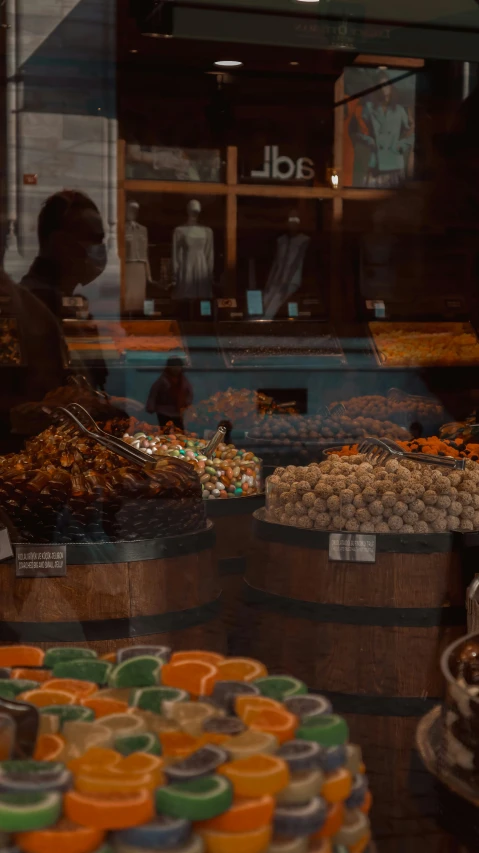 a store window filled with lots of different types of food, by Daniel Lieske, pexels contest winner, hyperrealism, barrels, candies, profile, brown