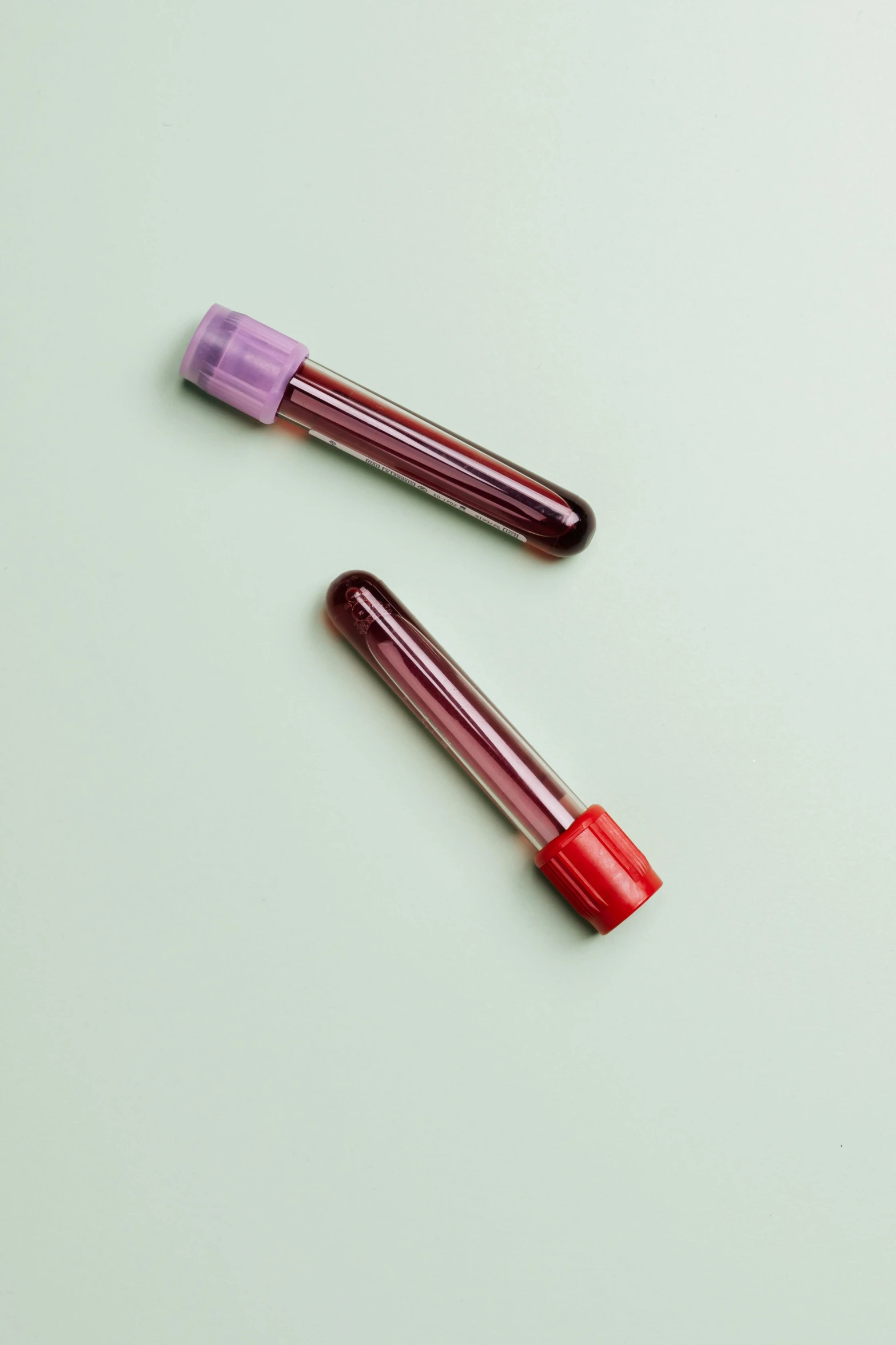 two tubes of blood on a green surface, trending on pexels, purple tubes, on a pale background, 240p, hgh