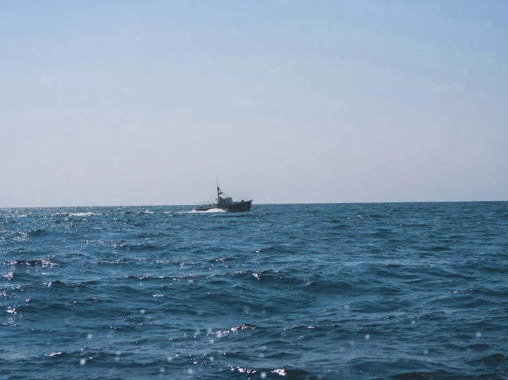 a boat in the middle of a large body of water, a picture, unsplash, hurufiyya, black sea, 2000s photo