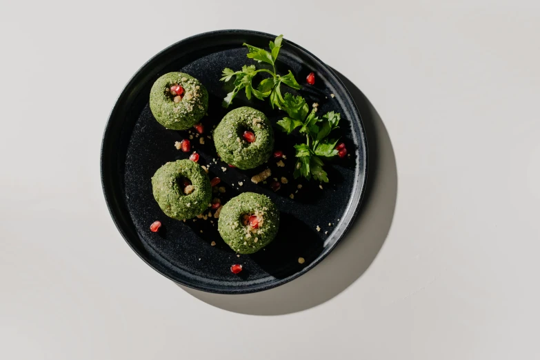 a close up of a plate of food on a table, black and green, hgrenades, seeds, detailed product image