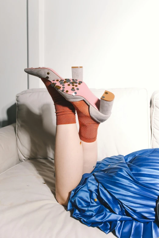 a woman laying on a couch with her feet up, inspired by Sarah Lucas, trending on pexels, renaissance, pink shoes, wearing kneesocks, petra cortright, embroidered velvet