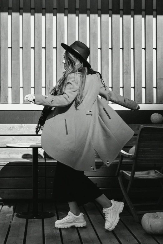 a black and white photo of a woman sitting on a bench, pexels contest winner, straw hat and overcoat, she is dancing. realistic, back pose, 15081959 21121991 01012000 4k