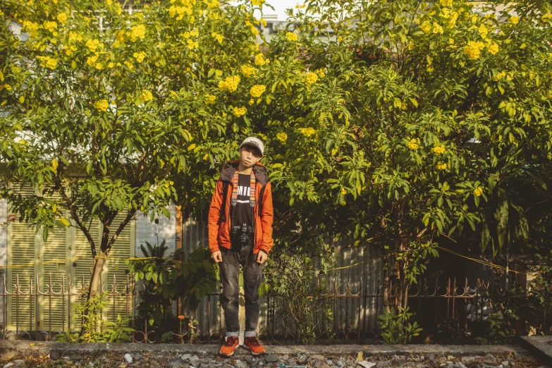 a man with a shovel standing in front of a tree, a portrait, unsplash, visual art, she is wearing streetwear, orange plants, anime style mixed with fujifilm, in style of lam manh