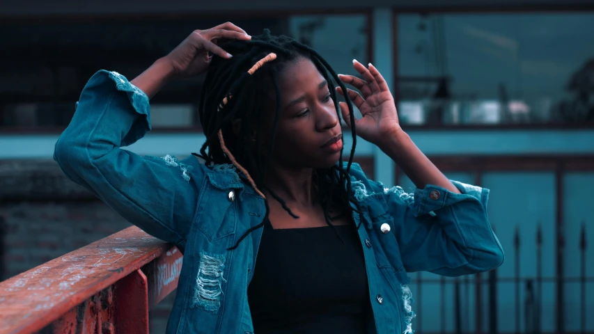 a woman with dreadlocks standing on a bridge, trending on pexels, realism, wearing a jeans jackets, thinker pose, ☁🌪🌙👩🏾, photo of a black woman