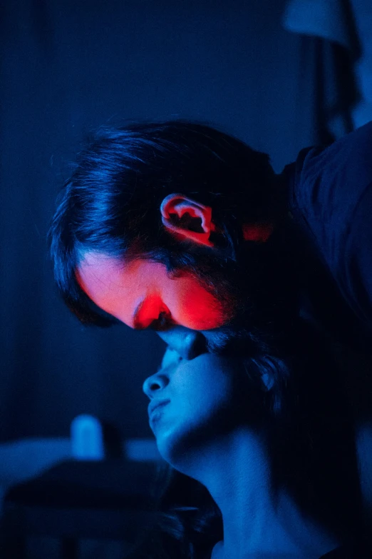 a man standing next to a woman in a dark room, inspired by Nan Goldin, romanticism, blue and red lighting, making out, ((blue)), 2019 trending photo