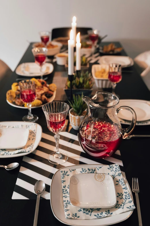 a black table topped with plates and silverware, holiday vibe, drinking, profile image, food