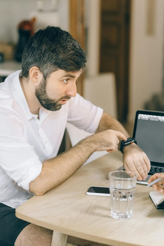 a man and woman sitting at a table with a laptop, trending on pexels, professional profile picture, scruffy man, zachary corzine, in an action pose
