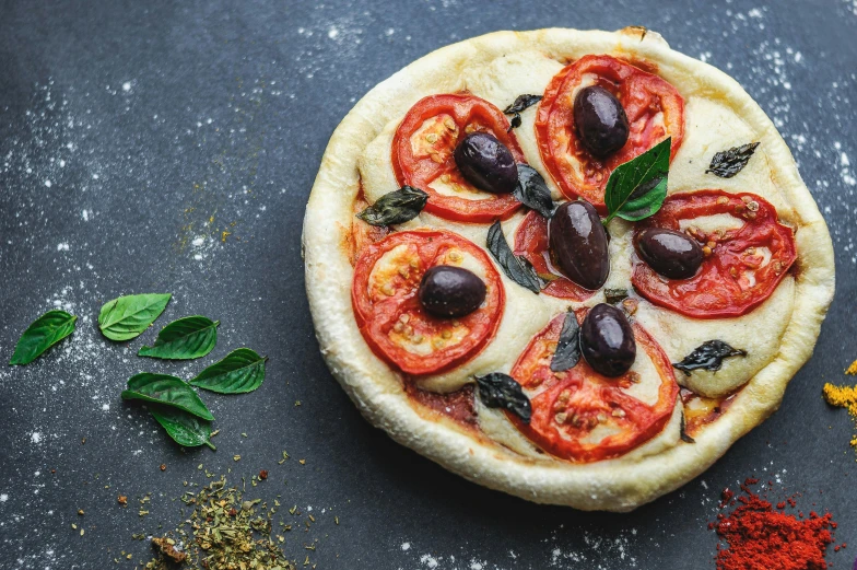 a pizza with tomatoes and olives on a table, by Julia Pishtar, on grey background, 15081959 21121991 01012000 4k, middle eastern skin, thumbnail