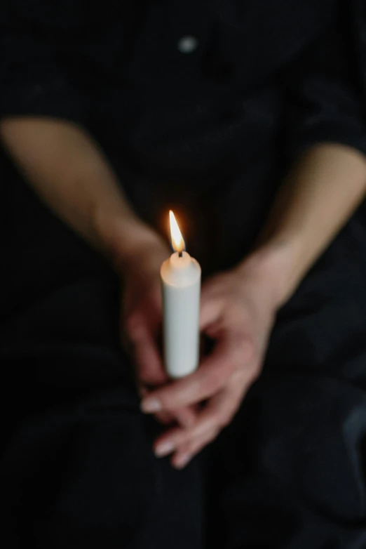 a person holding a lit candle in their hands, trending on pexels, portrait of mournful, white ribbon, instagram post, ilustration