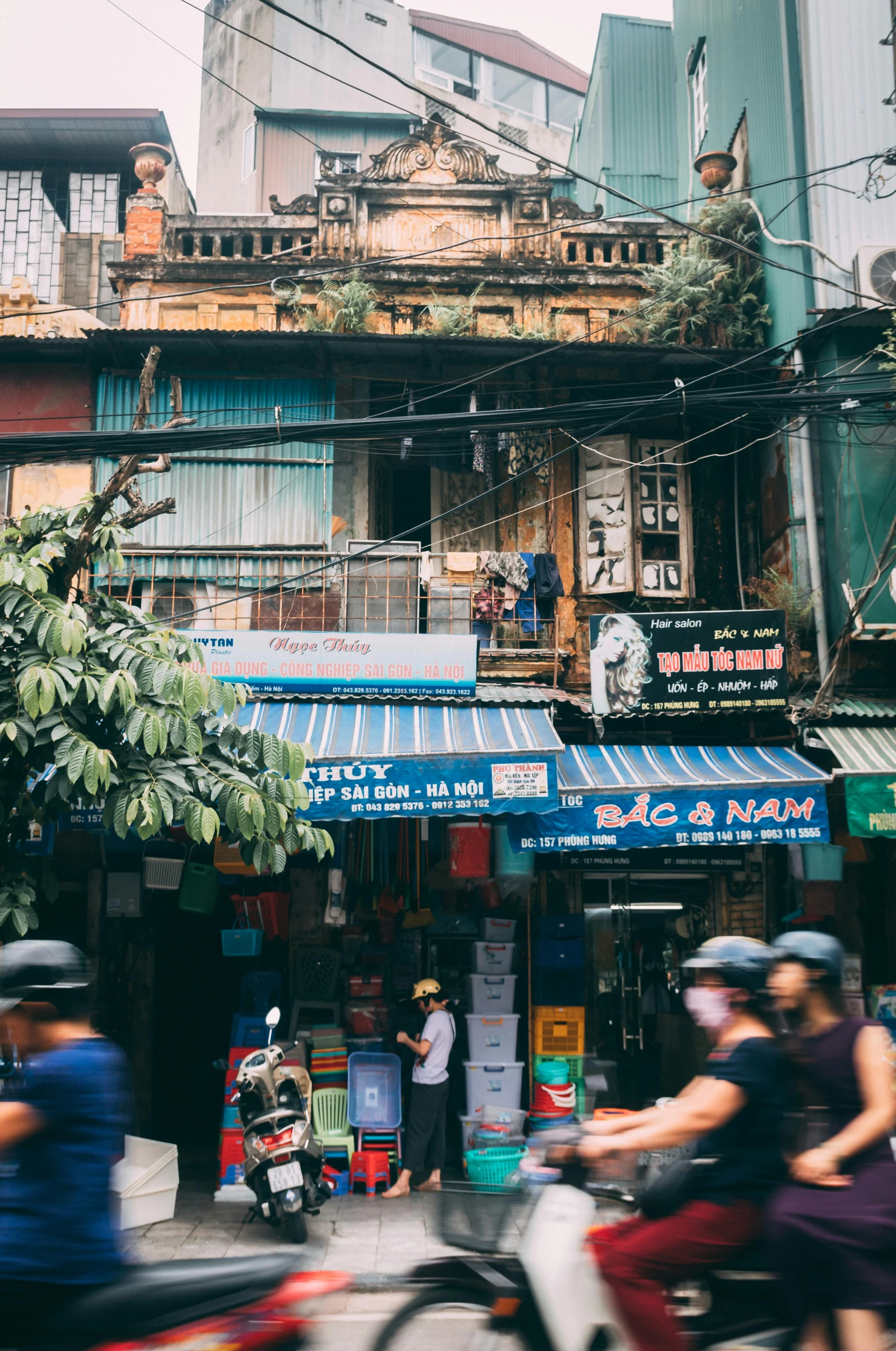 a group of people riding motorcycles down a street, by Sam Dillemans, trending on unsplash, chinese building, hoang lap, old shops, background image