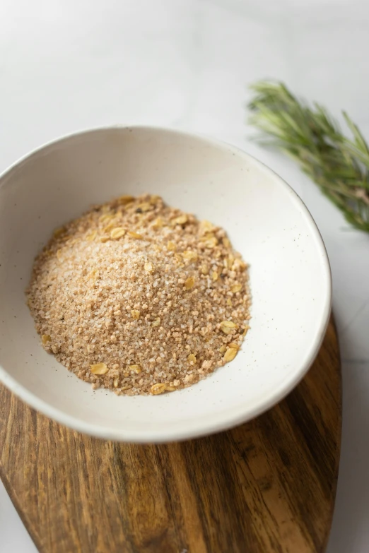 a white bowl sitting on top of a wooden cutting board, by Kristin Nelson, gold flakes, spices, sandman, pine