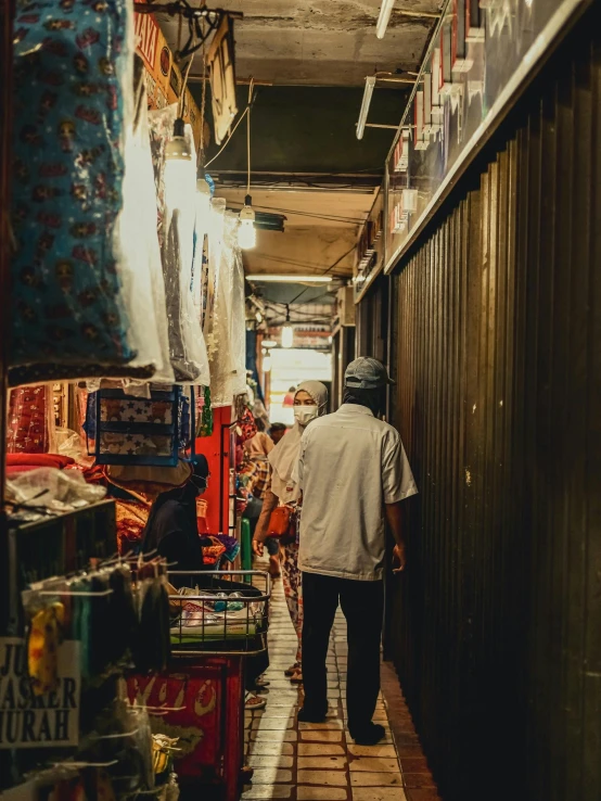 a man walking down a narrow alley way, by Benjamin Block, pexels contest winner, inside an arabian market bazaar, jakarta, japanese streetwear, early evening