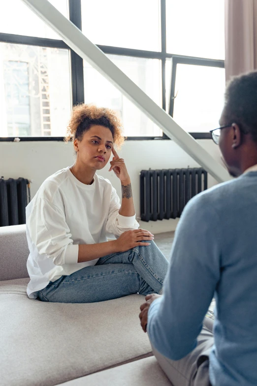 a man and a woman sitting on a couch in a living room, pexels, talking, healing, african american young woman, sitting in an empty white room