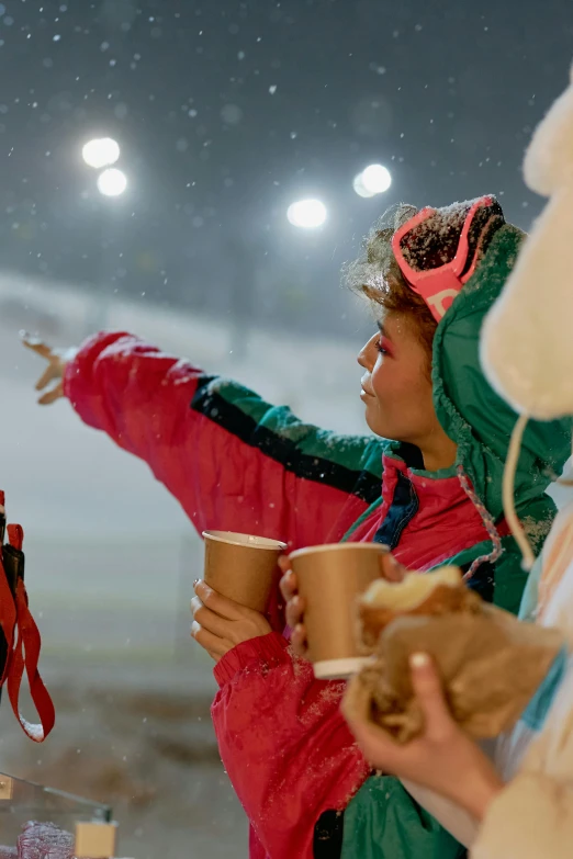a group of people standing next to each other in the snow, woman drinking coffee, on a racetrack, nighttime, profile image