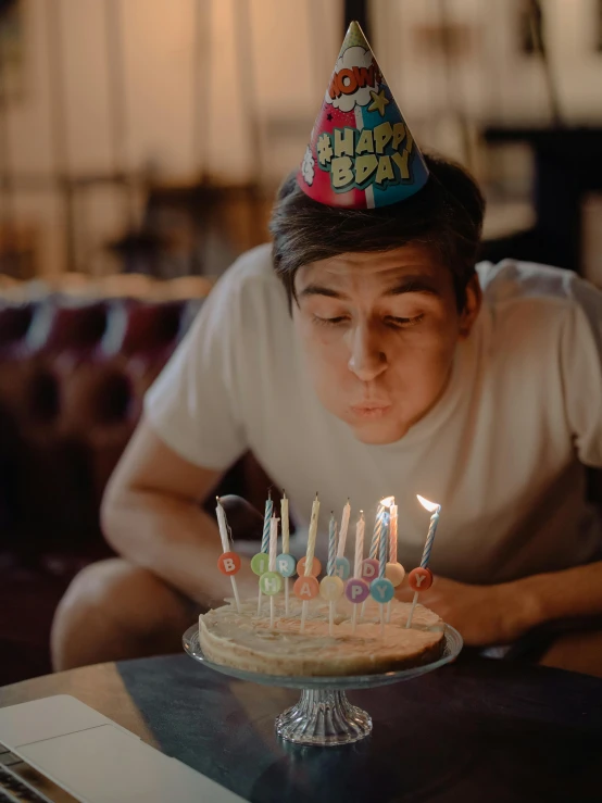 a man blowing out candles on a birthday cake, a colorized photo, by Adam Marczyński, pexels contest winner, bo burnham, bisexual lighting, background image, video