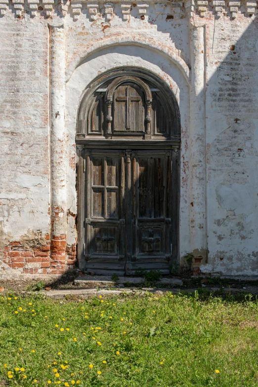 an old brick building with a wooden door, an album cover, inspired by Isaac Levitan, pexels contest winner, romanesque, destroyed church, exterior photo, summer light, savrasov