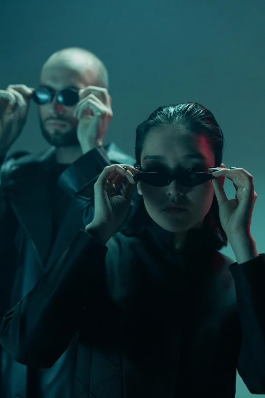 a group of people standing next to each other, an album cover, inspired by Elsa Bleda, trending on pexels, futurism, wearing shiny black goggles, movie still from the matrix, sasha grey, portrait of two people