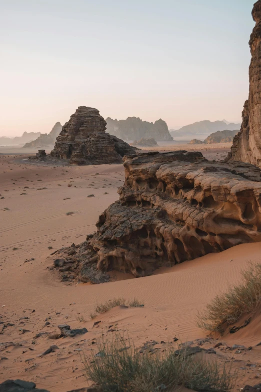 a rock formation in the middle of a desert, early dawn, tombs, red sand beach, epic land formations