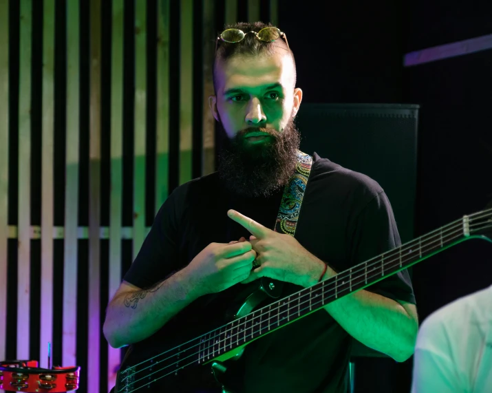 a man with a beard playing a bass guitar, pexels contest winner, hurufiyya, charli bowater and artgeem, looking to his side, sam nassour, technical