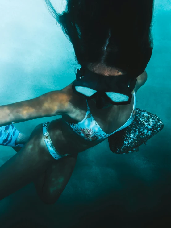 a woman in a bikini and goggles swims under water, inspired by Elsa Bleda, unsplash contest winner, wearing labradorite body armor, “diamonds, 2019 trending photo, scuba mask