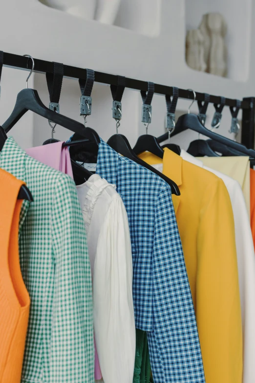 a row of colorful shirts hanging on a rack, trending on unsplash, renaissance, grid of styles, wearing a cropped top, tech robes, in style of juergen teller