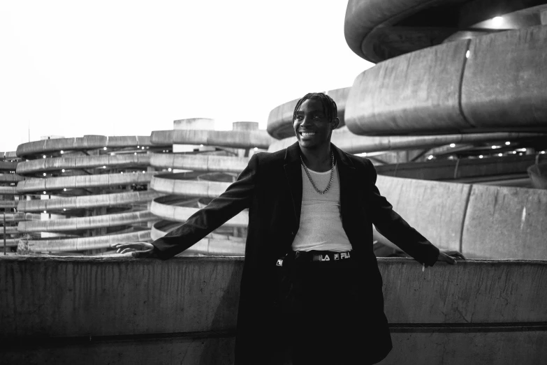 a black and white photo of a man standing in front of a building, an album cover, pexels, album art young thug, doing an elegant pose, 15081959 21121991 01012000 4k, playboi carti portrait