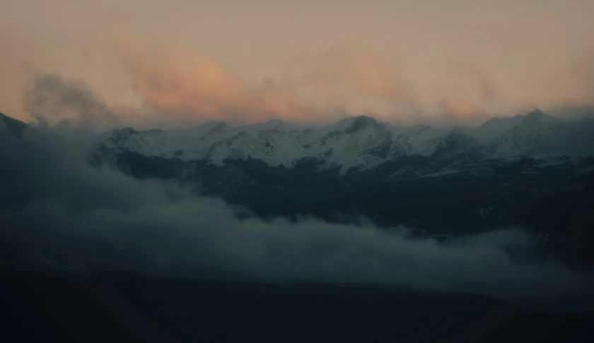 a view of a mountain range with clouds in the foreground, pexels contest winner, romanticism, faded glow, snowy mountains, grey, early evening