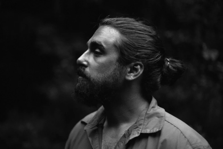 a man with long hair and a beard, a black and white photo, by Caro Niederer, unsplash, ponytail and beard, half turtle, portrait of forest gog, low light