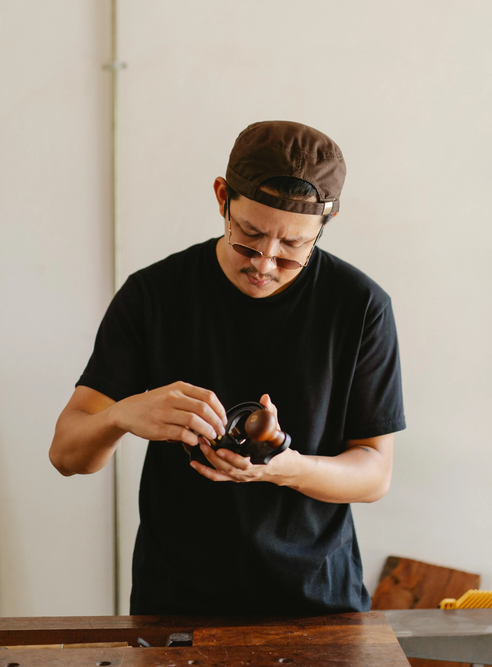 a man standing in front of a table holding a camera, a bronze sculpture, by Nyuju Stumpy Brown, unsplash, holding an avocado in his hand, in karuizawa, chocolate frosting, profile image