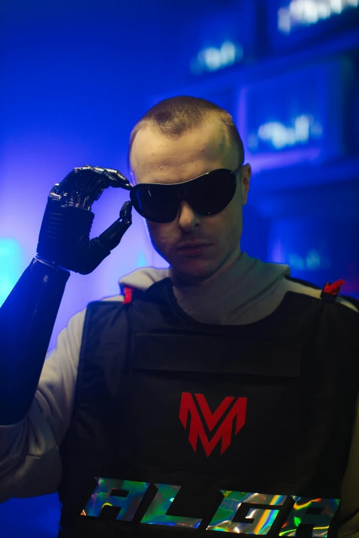 a man in a black vest and sunglasses talking on a cell phone, an album cover, inspired by Adam Marczyński, featured on reddit, futurism, flight suit and gloves, buzz cut, techwear clothes, mk ninja