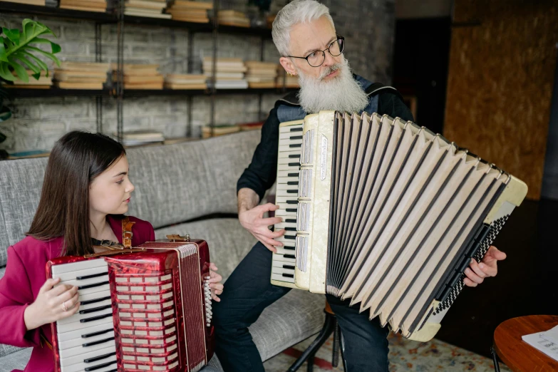 a man playing an accordion with a little girl, an album cover, by Konrad Witz, pexels contest winner, overalls and a white beard, aurora aksnes, at home, schools