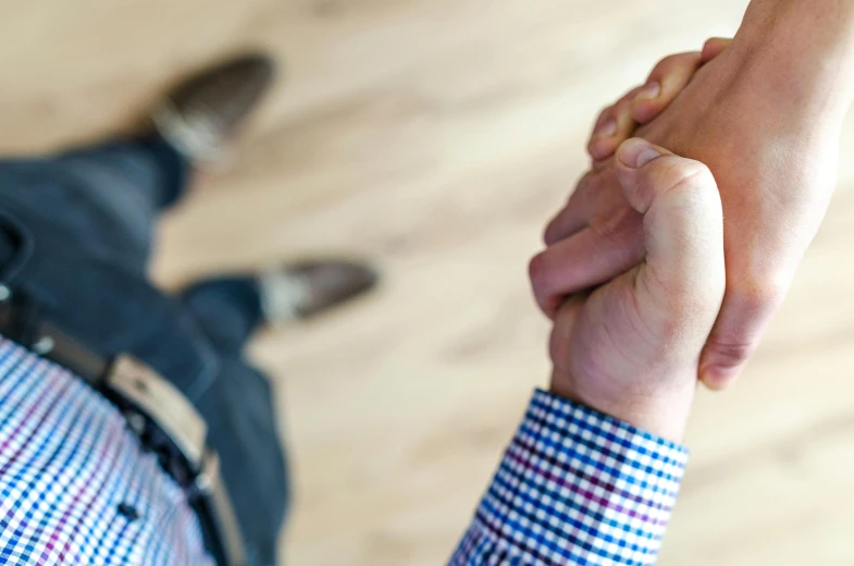 a close up of two people holding hands, pexels, giving an interview, birdseye view, kneeling, realistic image