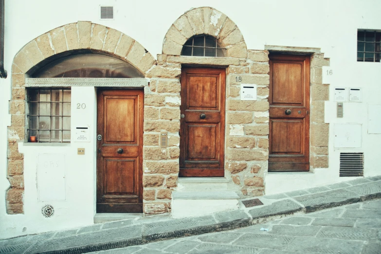 a couple of wooden doors sitting on the side of a building, pexels contest winner, renaissance, staggered terraces, the three moiras, 90s photo, built on a steep hill