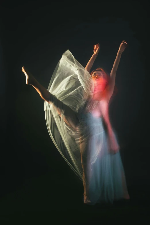 a woman in a white dress is dancing in the dark, a portrait, pexels contest winner, light and space, diaphanous iridescent silks, with a red halo over her head, sports photo, soaring