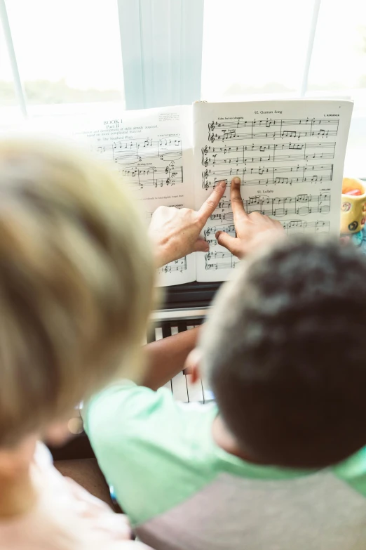 a group of people sitting around a piano