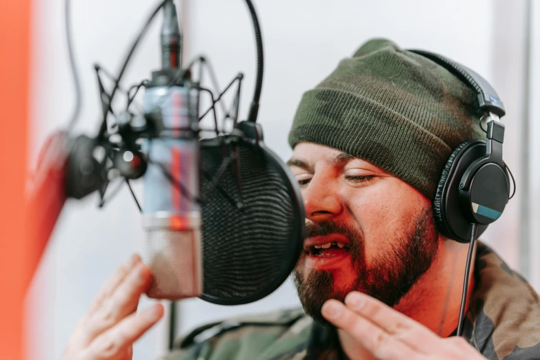 a man singing into a microphone in a recording studio, an album cover, by Matija Jama, pexels, wearing camo, goatee, instagram post, lachlan bailey