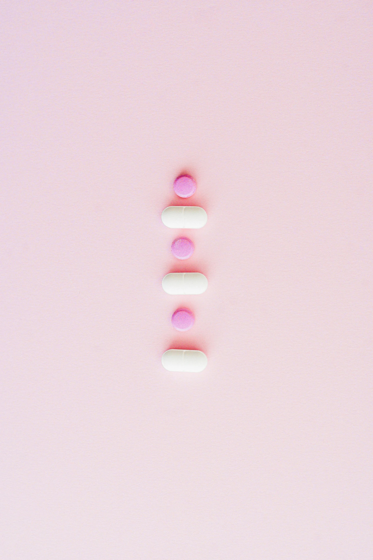 pills arranged in a row on a pink background, by Matteo Pérez, aestheticism, thedieline, back facing, milk, v