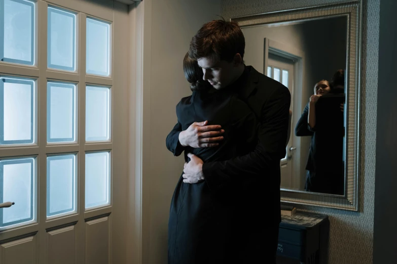 a man hugging a woman in front of a mirror, pexels contest winner, symbolism, dramatic movie still, leaving a room, ( ( theatrical ) ), mourning
