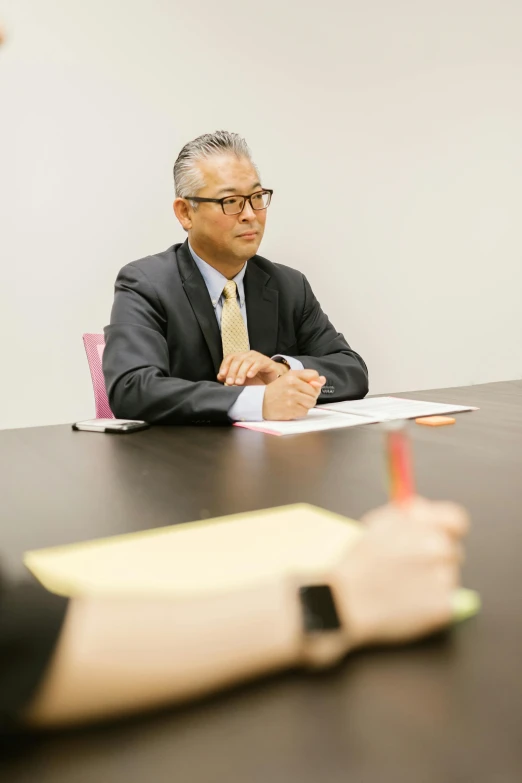 a group of people sitting around a table, shin hanga, wearing a business suit, color photograph, professional profile photo, person in foreground