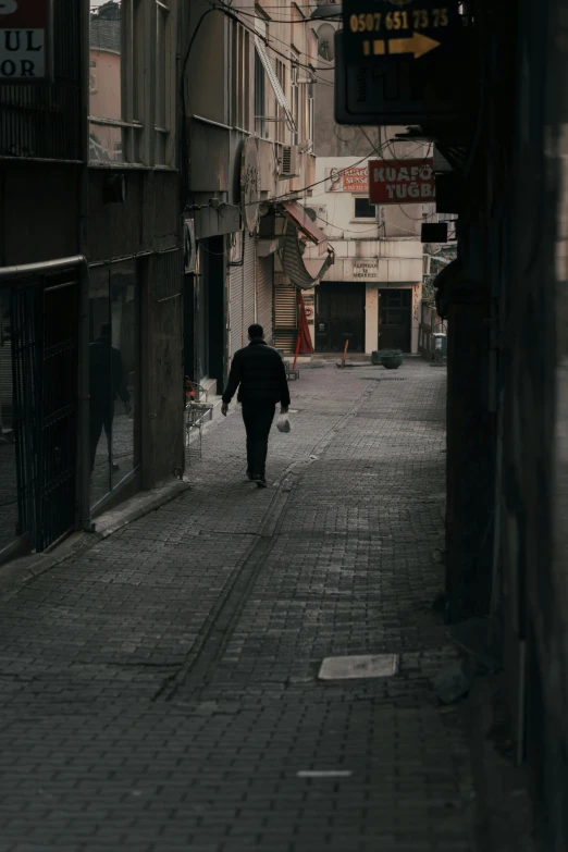 a person walking down a narrow city street, desolate, istanbul, man in black, unsplash photography